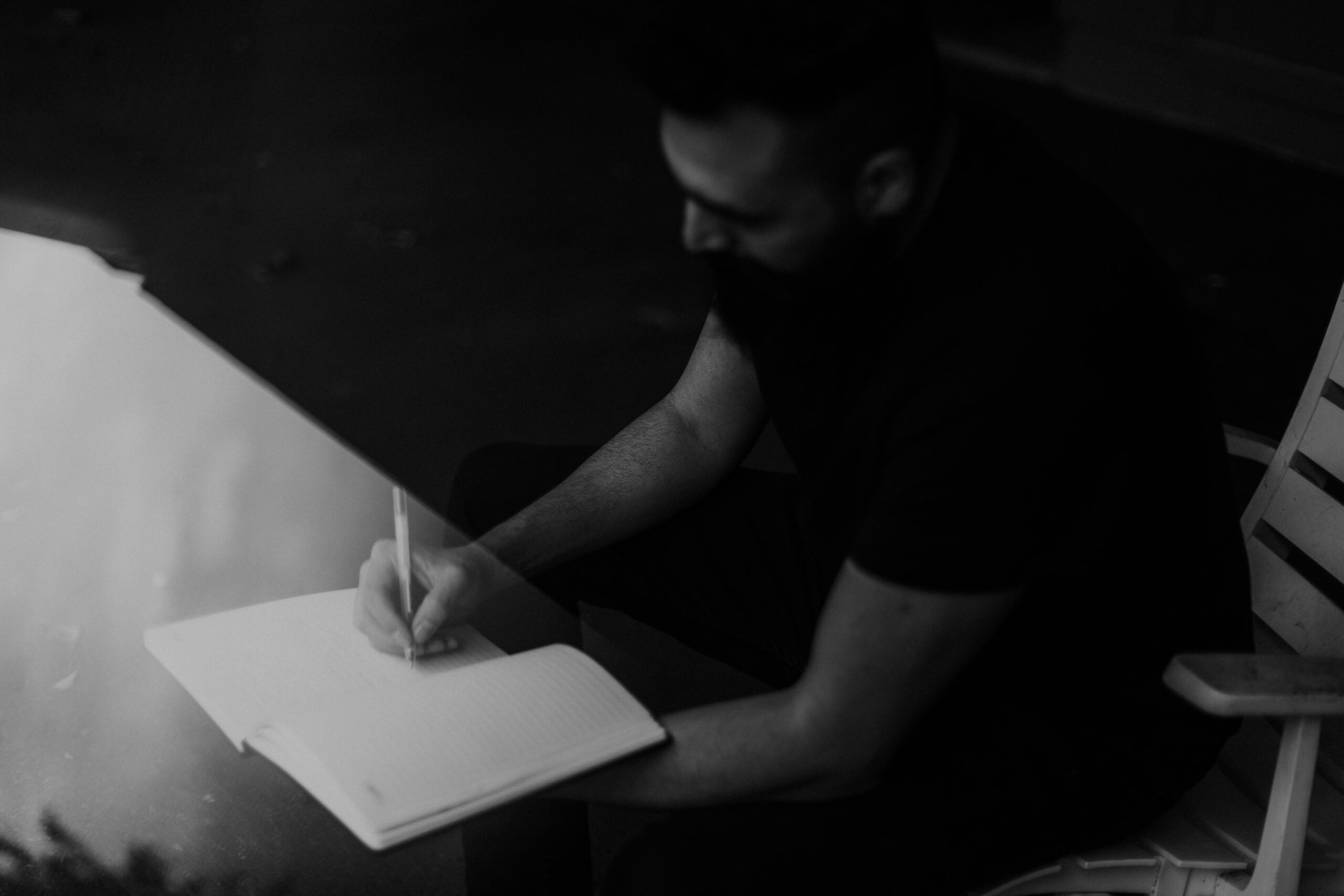 Man writing in a journal, black and white